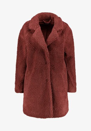 Takki pehmeästä, teksturoidusta kankaasta, syvän ruosteenpunaisessa värissä. Ominaisuuksiin kuuluu lovettu kaulus, etunapit ja puolipitkä malli.