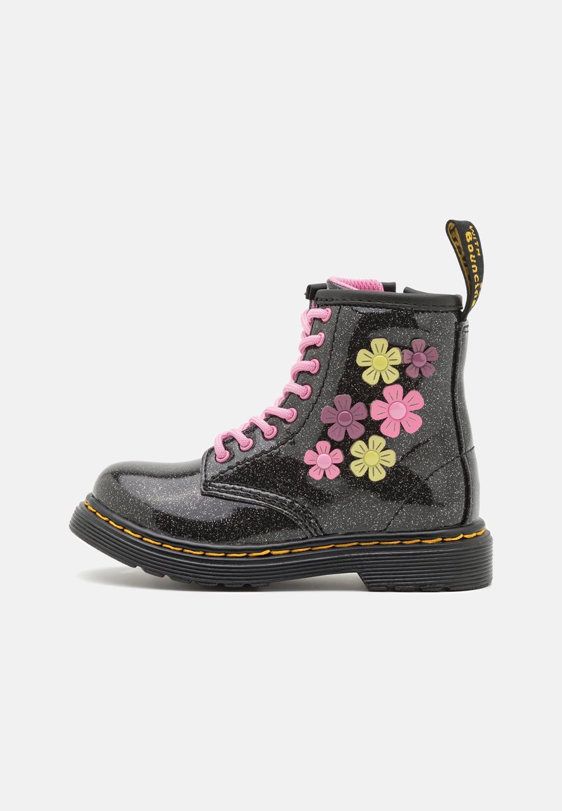 Botte noire pailletée à lacets rose, avec des appliques florales jaunes et roses sur le côté, et une semelle épaisse noire avec des coutures jaunes.