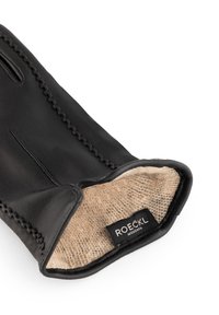 Schwarzer Lederhandschuh mit beigefarbenem Futter, sichtbaren Nähten entlang der Kanten und einem Etikett mit der Aufschrift "ROECKL MÜNCHEN" am Öffnung