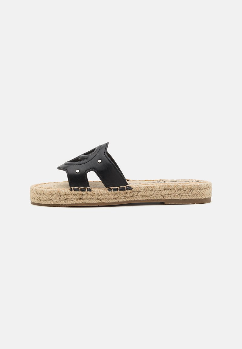 Sandal in pelle nera a scivolo con design a intagli, suola in juta intrecciata e accenti cuciti. La suola presenta una forma piatta con una texture naturale.