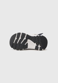 Fekete-fehér gumitalpú gyereksneaker, textúrázott tapadással és a "KEEN" márka logójával, sima fehér háttér előtt.