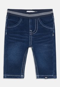 Blå denimshorts med mörk tvätt, vit sömnad och randig elastisk midja. Har framfickor och en logotagg vid fållen.