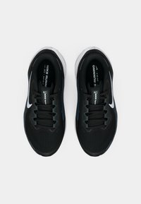 Adidași negri pentru alergare cu un upper din plasă, șireturi negre, logo alb Nike și o talpă amortizată. Prezintă un vârf texturat și un guler căptușit.