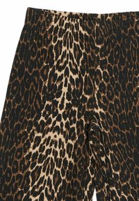 Leggingi s uzorkom leoparda u crnoj, smeđoj i bež boji. Napravljeni su od mekanog materijala s elastičnom trakom u struku i teksturiranom finišu.