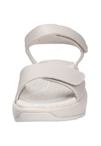 Sandalias en un beige claro con dos correas anchas y texturizadas. Cuentan con una suela acolchada y una plantilla estampada. Diseño de correas ajustables.