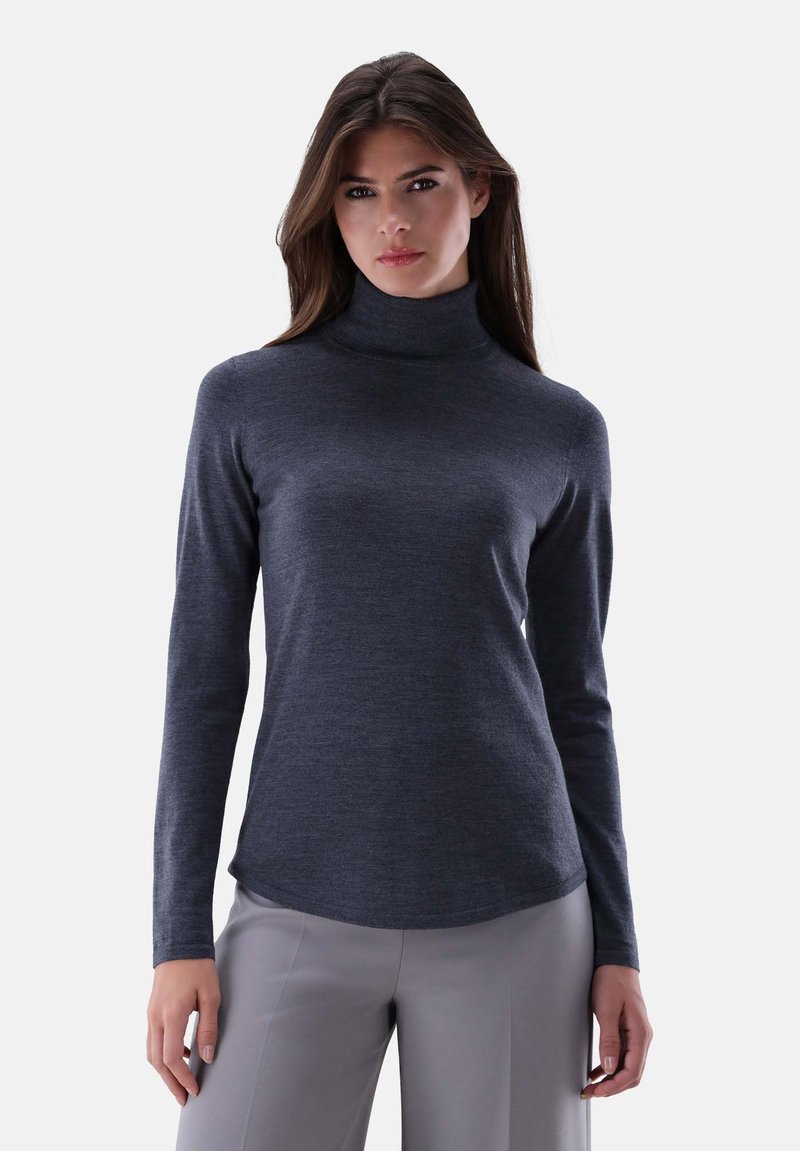 Dunkelgrauer Rollkragenpullover aus weichem Strickmaterial, mit langen Ärmeln und leicht abgerundetem Saum, kombiniert mit hellgrauen Hosen.