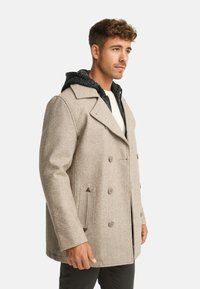 Cappotto beige in misto lana con design doppiopetto, colletto con risvolto e cappuccio grigio testurizzato visibile sotto. Dettagli con bottoni marroni.