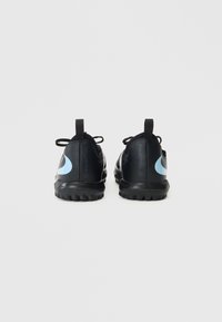 Fekete sportcipők sima, matt felülettel, világoskék swoosh logóval, struktúrált talppal és fekete cipőfűzőkkel.