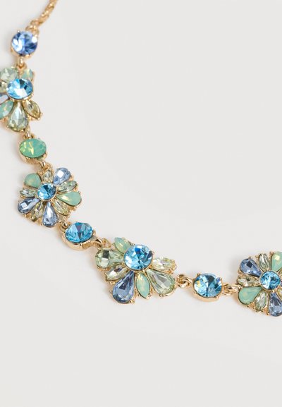 Χρυσό κολιέ με αλυσίδα και συστάδες σε σχήμα λουλουδιού από μπλε, πράσινους και διάφανους πολύπλευρους πολύτιμους λίθους σε λευκό φόντο.