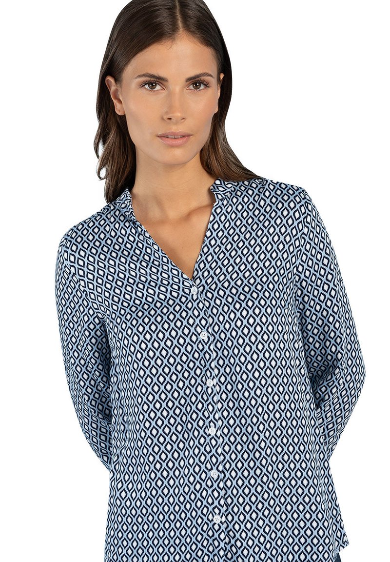 Navy and white patterned button-up shirt with a V-neck, long sleeves, and diamond-shaped designs throughout. Soft fabric texture.