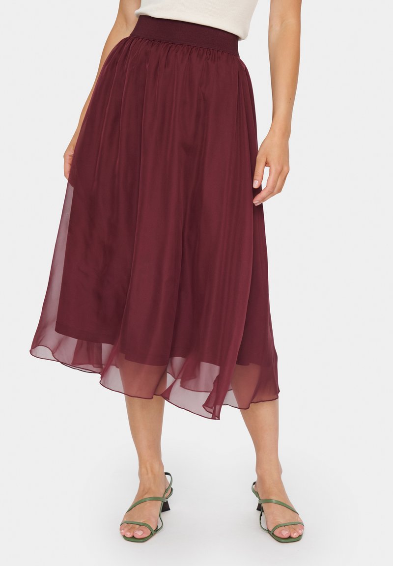 Fustă midi burgundy dintr-un material ușor, fluid; dispune de un brâu elastic și un tiv stratificat pentru un plus de textură și mișcare.