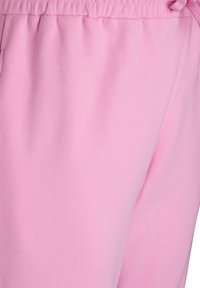 Helle rosa Sweatpants mit elastischem Bund, ausgestattet mit einer glatten Textur und einem Kordelzugdetail zur Anpassung.