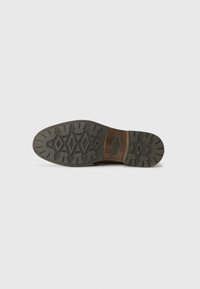 Semelle d'une chaussure avec un extérieur en caoutchouc texturé de couleur gris foncé, avec un fini texturé et un accent en cuir brun au talon.