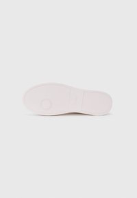Sole di scarpa in gomma rosa chiaro con superficie texturizzata, dettaglio con motivo circolare e branding in rilievo. Presenta un design a punta rotonda.
