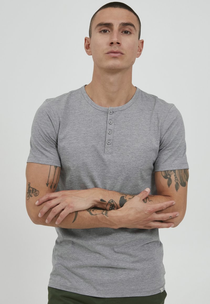 Gray short-sleeve henley t-shirt featuring three button placket, soft texture, and fitted design, set against a plain background.