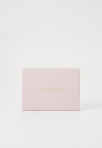 Pink rectangular box with a matte finish. Front features the brand name "COCCINELLE" in gold text. Simple design with no patterns or hardware.