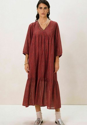 Robe maxi à motif rouge avec un décolleté en V, des manches trois-quarts et un ourlet à volants. Fabriquée en tissu léger avec une silhouette fluide.