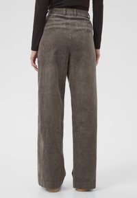 Wijde corduroy broeken in een gedempt grijs-bruin kleur met verticale ribben, voorzien van een hoge tailleband en twee achterzakken.