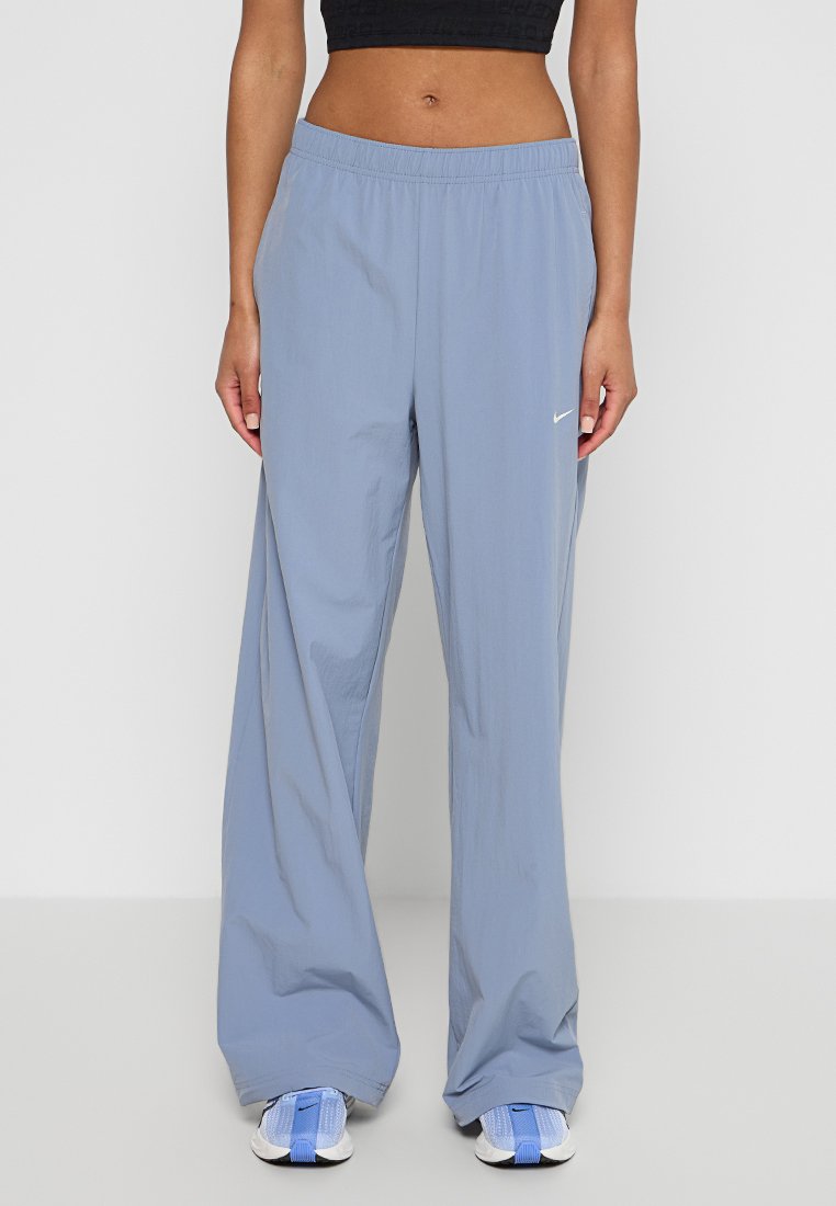 Pantalones deportivos de color azul claro hechos de un tejido ligero, con un corte relajado, cinturilla elástica y un pequeño logo blanco en el lado izquierdo.