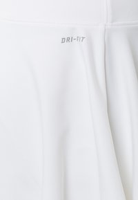 Valkoinen DRI-FIT-hame, joka on valmistettu kevyestä, kosteutta siirtävästä kankaasta. Hameessa on sileä pinta, hieman levenevä alaosa ja ommellut saumat.