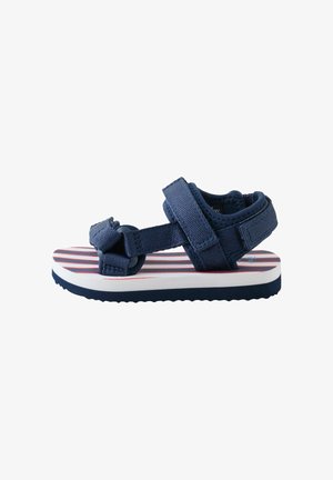 Sandalo per bambino in blu navy con cinturini regolabili e suola imbottita con strisce rosse e bianche, mostrato di profilo su sfondo bianco.