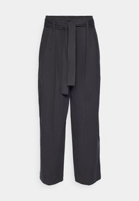 Pantalon large gris foncé avec une taille haute ceinturée, tissu lisse et poches latérales. Les ourlets sont légèrement resserrés.