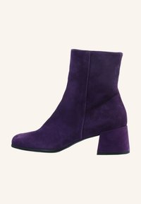Bottine en daim violet avec talon bloc et bout arrondi, profil latéral sur fond uni clair.