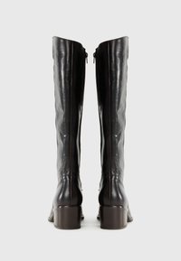 Svart lær knee-high støvler med en glatt tekstur, en rund tå og en blokkhelt. Har en glidelås på yttersiden.
