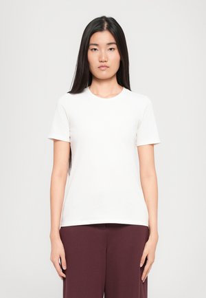 Weißes Baumwoll-T-Shirt mit kurzen Ärmeln und rundem Ausschnitt, auf einem Modell vor einem schlichten Hintergrund präsentiert.