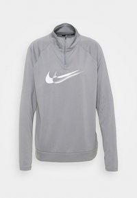 Pullover grigio a maniche lunghe realizzato in tessuto morbido, con collo a mezza zip e un grande logo Nike bianco sul petto.