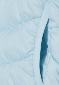 Hellblauer Pufferjackenstoff mit gesteppten Abschnitten, glatter Textur und einem kontrastierenden, weichen Futter entlang der Kanten.