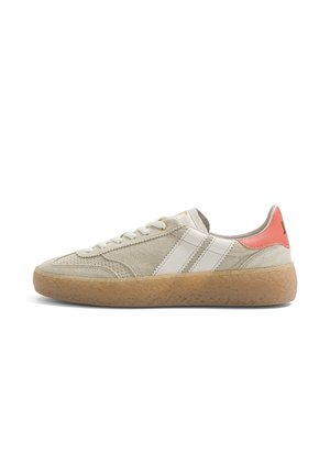 Beżowy zamszowy sneaker z białymi paskami, gumową podeszwą, białymi sznurowadłami i koralowym różowym akcentem na pięcie w widoku bocznym.