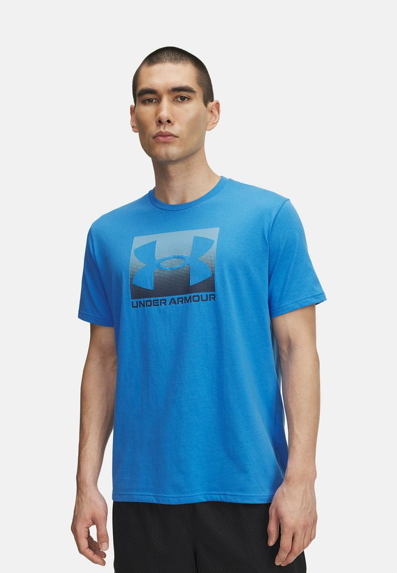 Sinine puuvillane T-särk lühikesed varrukad, mille esiküljel on suur tume sinine Under Armouri logo ruudukujulises kujunduses.