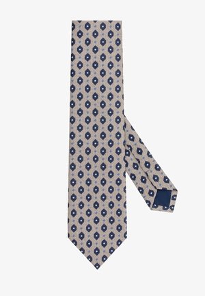 Beżowy krawat w geometryczny niebiesko-granatowy wzór w romby, z teksturowanym splotem i gładkim granatowym spodem.