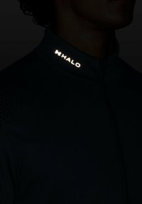 Black zip-up jacket with reflective "HALO" logo on the collar, featuring a smooth texture and breathable perforated detailing on the sleeves.