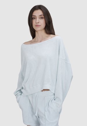 Hellblaue, übergroße Sweatshirt mit weitem Ausschnitt und überschnittenen Schultern, hergestellt aus einem weichen Stoff. Mit gerippten Bündchen und Saum.