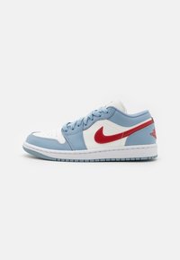 Low-top sneaker featuring a white leather base with light blue overlays and a red swoosh. Rubber sole with textured grip.