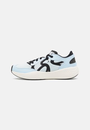 Zapatilla baja de color azul claro y blanco con detalles en negro, cordones negros y una suela blanca gruesa y texturizada vista de lado.