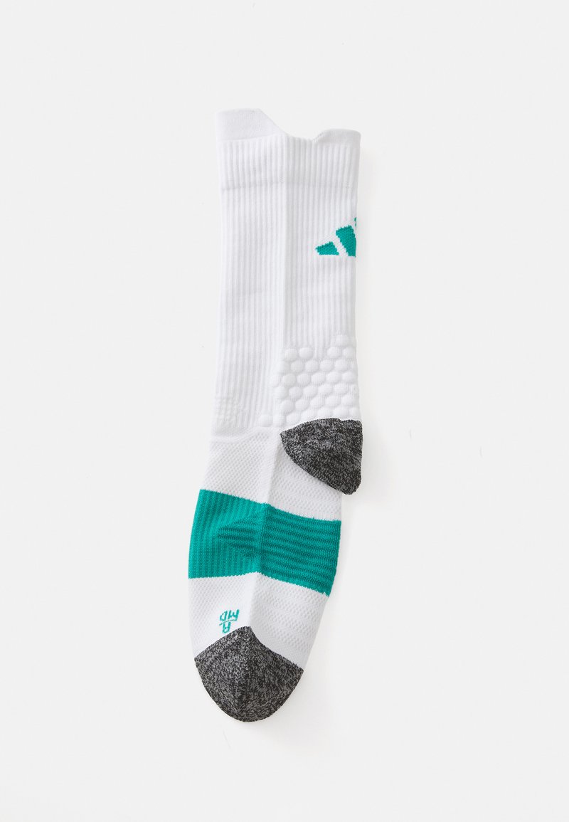 Chaussette de sport blanche avec des rayures turquoise, zones de grip texturées et un capuchon de doigt gris. Présente un design côtelé et un détail de marque sur le côté.