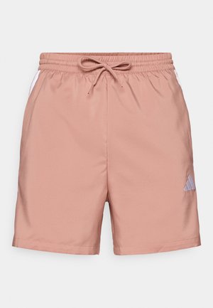 Shorts rose clair avec une taille élastique et un cordon de serrage. Présente des panneaux latéraux blancs et un petit logo Adidas bleu sur la jambe inférieure.
