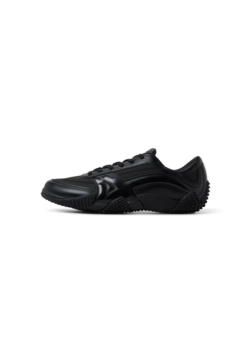 Zapatilla deportiva negra con un diseño elegante, hecha de cuero sintético. Presenta una suela texturizada, puntera redonda y seis ojales para los cordones.