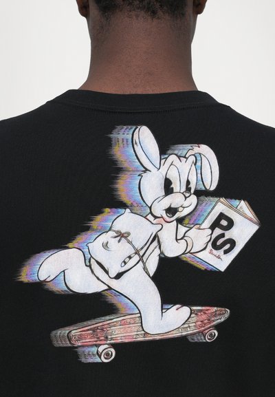 Black T-shirt featuring a colorful cartoon rabbit on a skateboard, holding a book labeled "PS," with a textured graphic design.