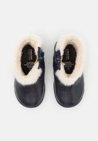 Czarne skórzane botki za kostkę z kremowym futerkiem sztucznym w środku i na brzegach, z zamkiem błyskawicznym i niebieskimi akcentami. Rozmiar 21, zaprojektowane z myślą o wentylacji.