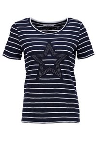 Camiseta a rayas en azul marino y blanco con cuello redondo y mangas cortas; presenta un diseño de estrella hecho de tachuelas plateadas en la parte delantera.