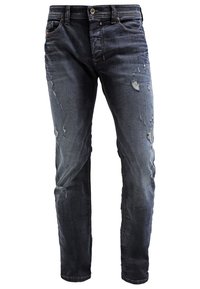 Mörkblå denimjeans med slitna detaljer och smal passform, med en klassisk femficksdesign och metallknappslås.