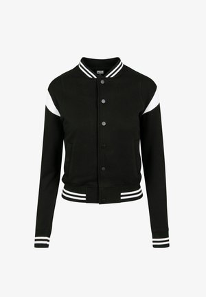 Mustmust läbimõõdud valge aktsentidega, ribitega varrukad ja alläär, nööbid, kaks küljetaskut, valmistatud pehmest kangast. Klassikaline spordidisain.