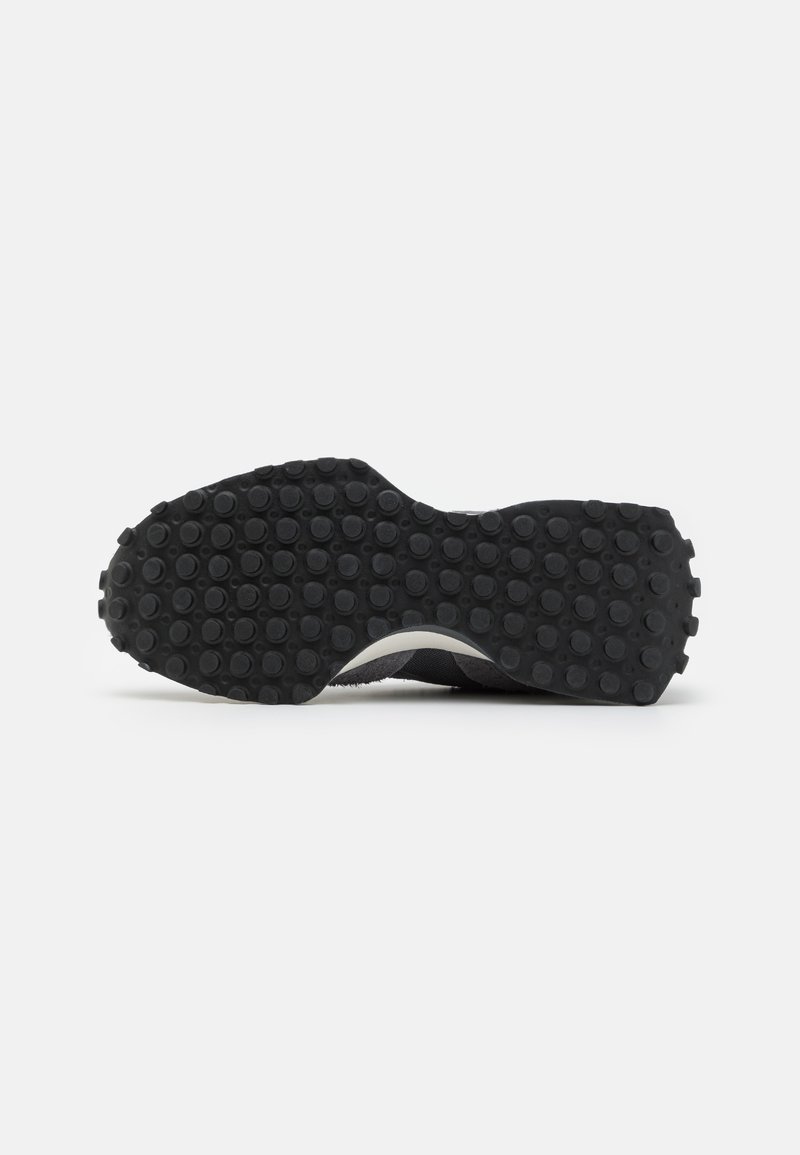 Suela de zapato de goma negra con superficie texturizada, que presenta bultos redondeados para tracción y una forma curva hacia el talón.