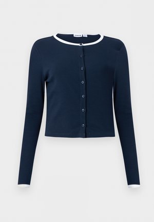 Granatowy kardigan na guziki z długim rękawem, z białą lamówką na kołnierzu i mankietach, wykonany z prążkowanej tkaniny, o kroju przedłużonym.