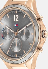 Reloj cronógrafo en oro rosa con un dial texturizado en gris, que presenta tres subdiales, una pantalla de fecha y marcadores de hora prominentes.