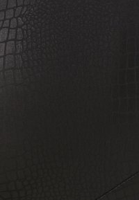 Black textured material with a crocodile skin pattern. The surface is smooth with a subtle sheen and visible stitching along the edge.